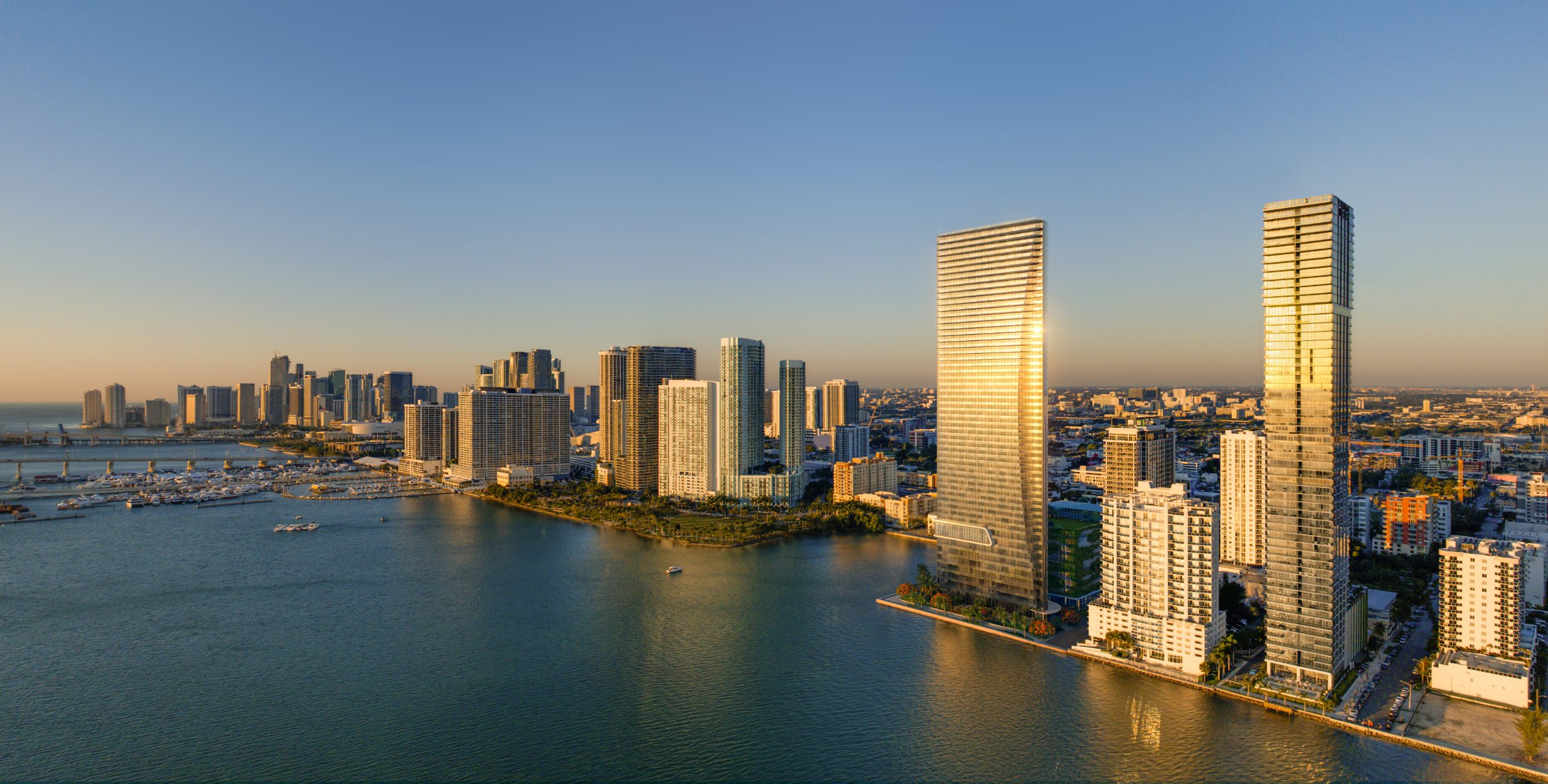 Aerial rendering of EDITION Residences Miami Edgewater on Biscayne Bay with the Miami skyline at golden hour